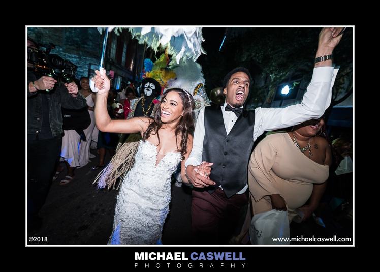 Bride and groom dance during second line parade in New Orleans