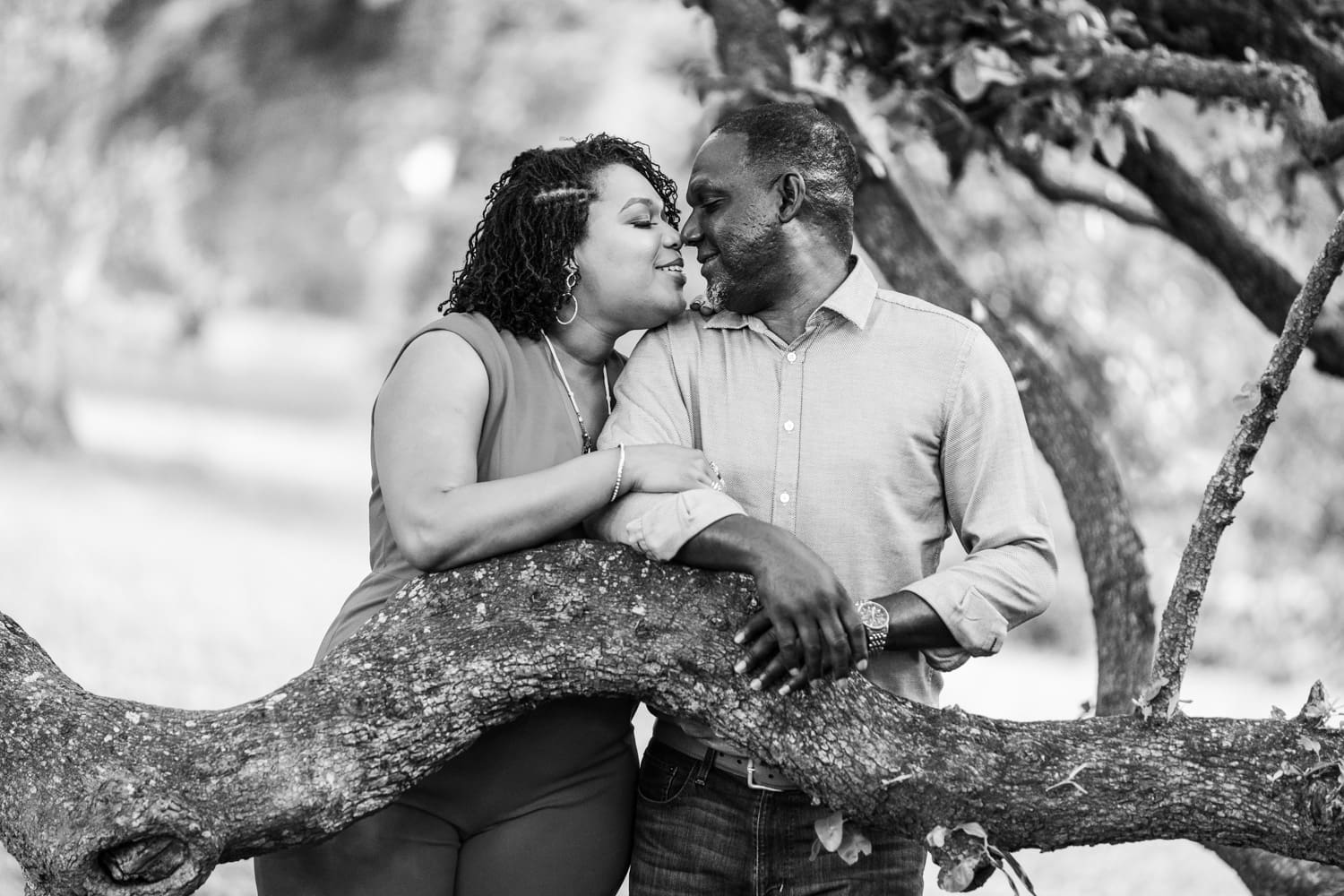 Couple kissing by tree branch in Audubon Park