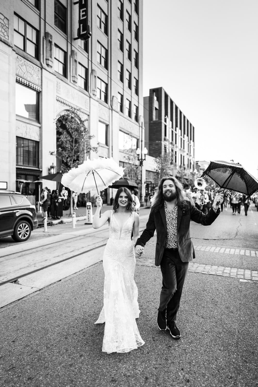 Bride and groom second line parade in front of Barnett Hotel