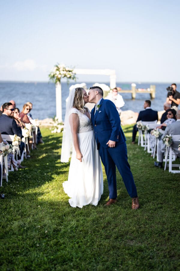 Brides kiss at Bay Waveland Yacht Club wedding ceremony