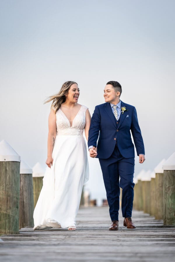 Couple walks along dock at Bay Waveland Yacht Club wedding