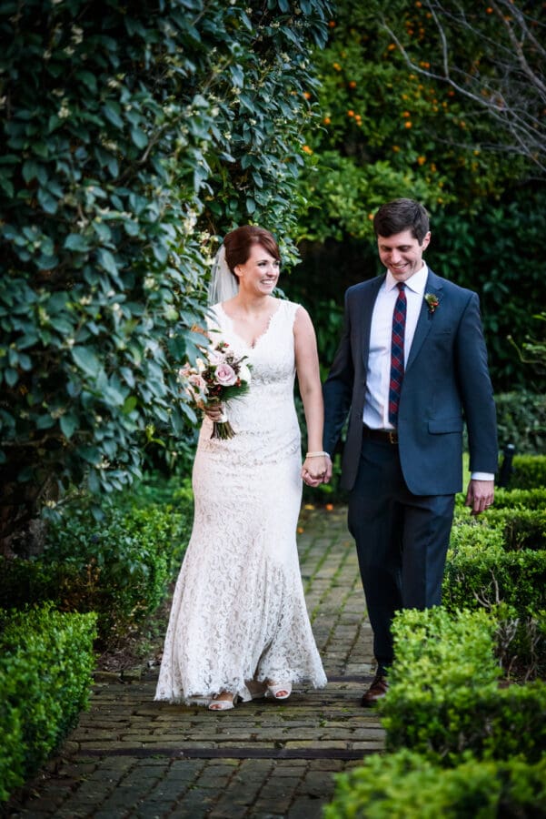 Bride and groom walk down brick pathway at Beauregard-Keyes House