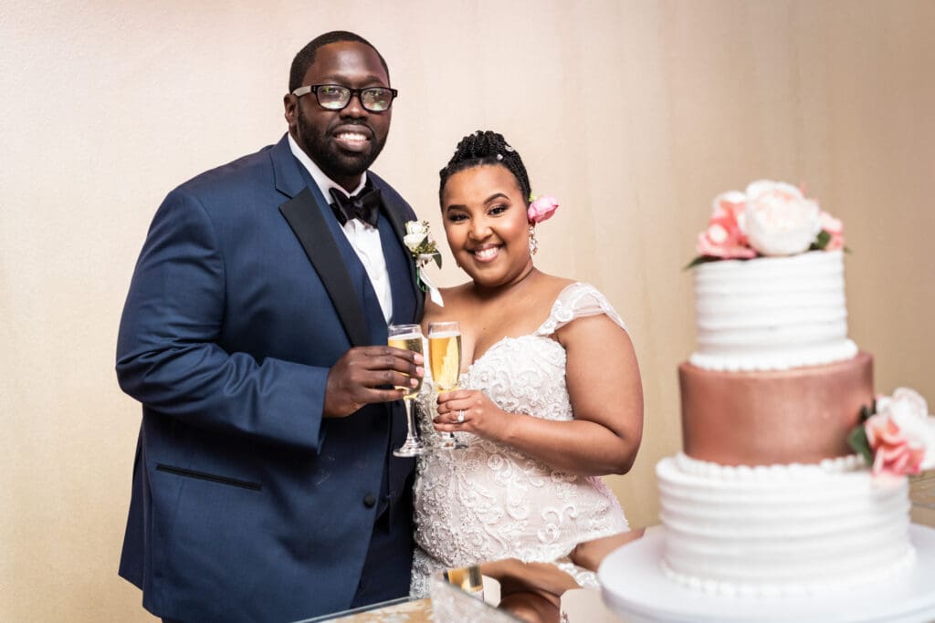 Bride and groom toasting at cake table