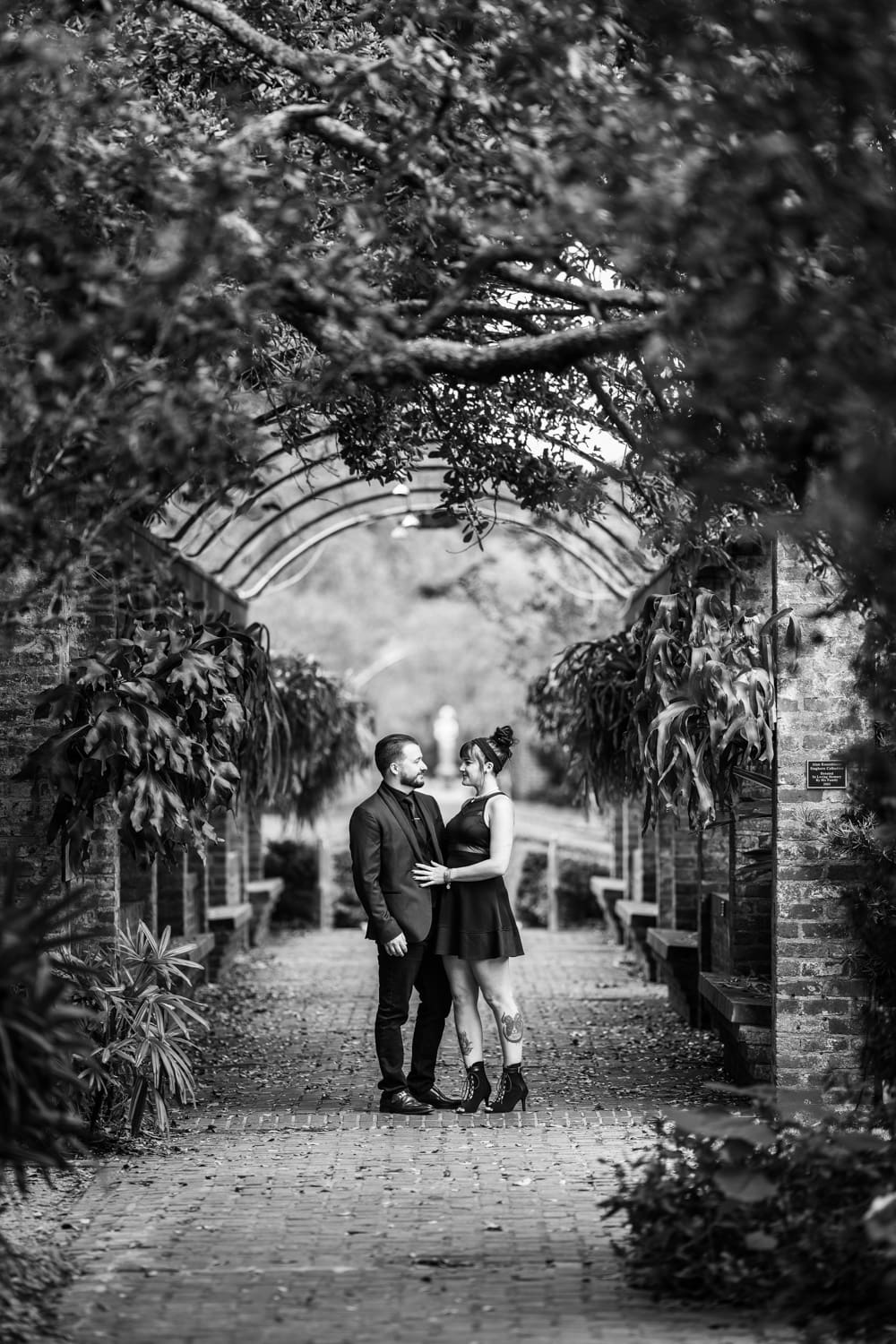 Couple standing in garden archway