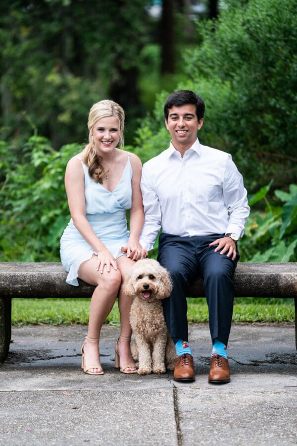 Couple sitting on bench in City Park with dog