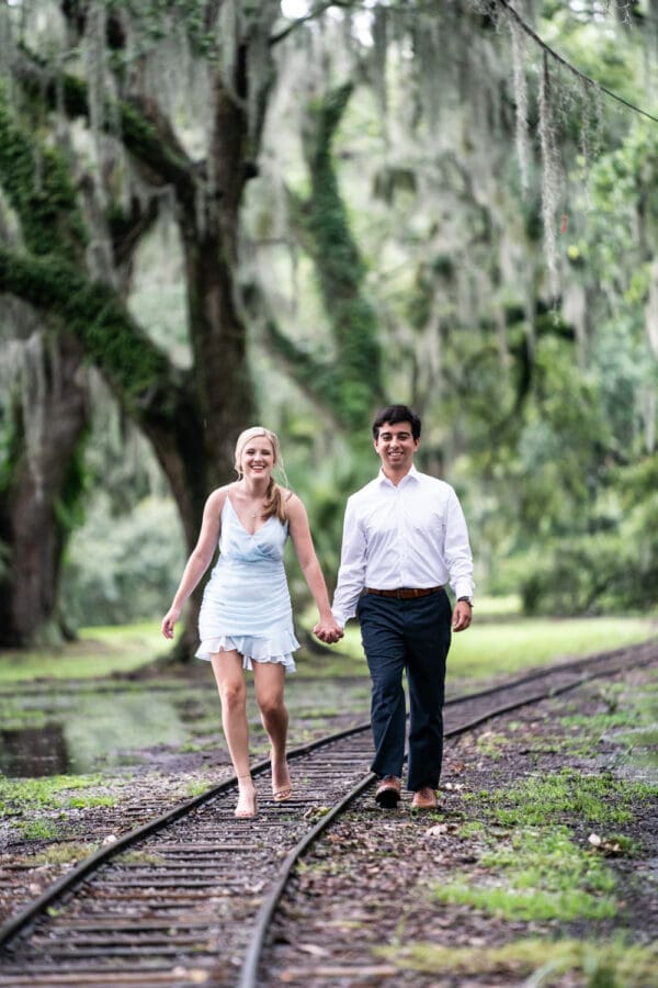 Couple walking along railroad tracks in the park