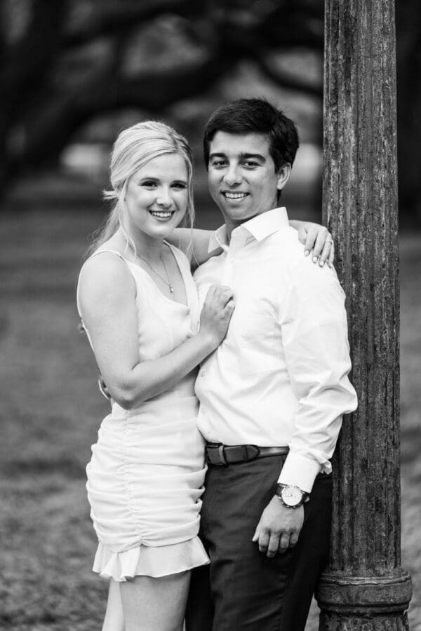 Couple standing by weathered lamp post in park