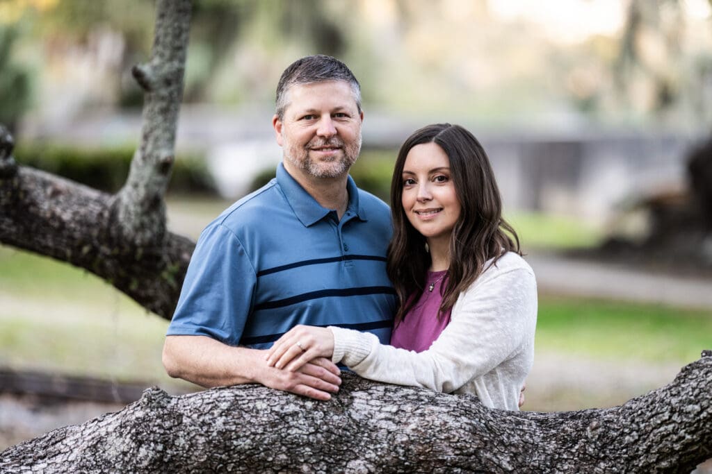 Couple standing by large tree branch