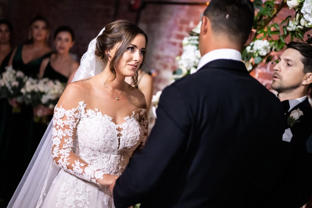 Bride listening to groom read his vows during Civic Theatre wedding ceremony