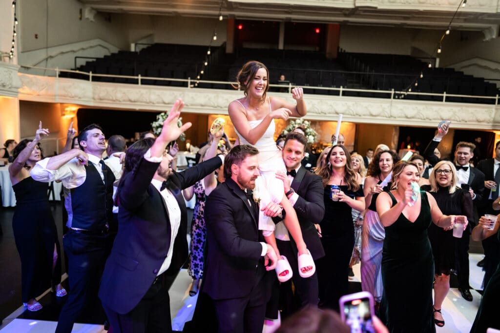 Guys lift up the bride during Civic Theatre wedding reception