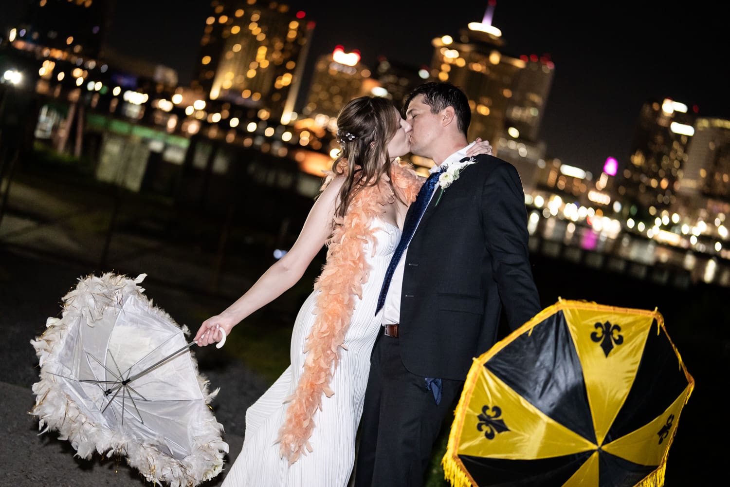 Couple kissing with New Orleans city skyline and river in background