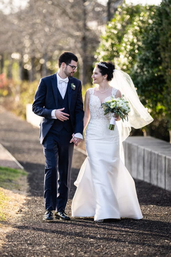 Bride and groom walking down path in Crescent Park