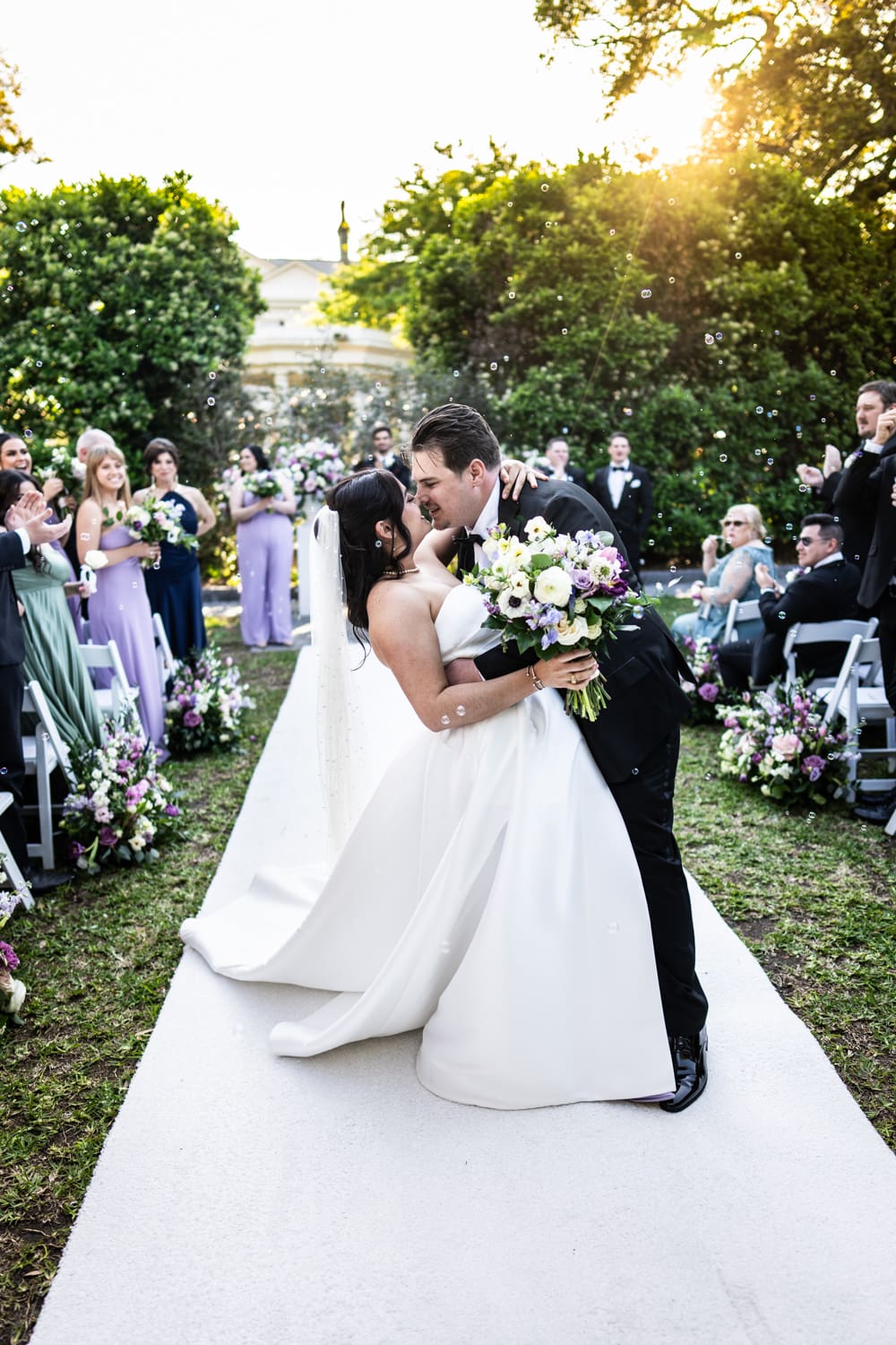 Couple kissing amidst bubbles at Elms Mansion wedding ceremony