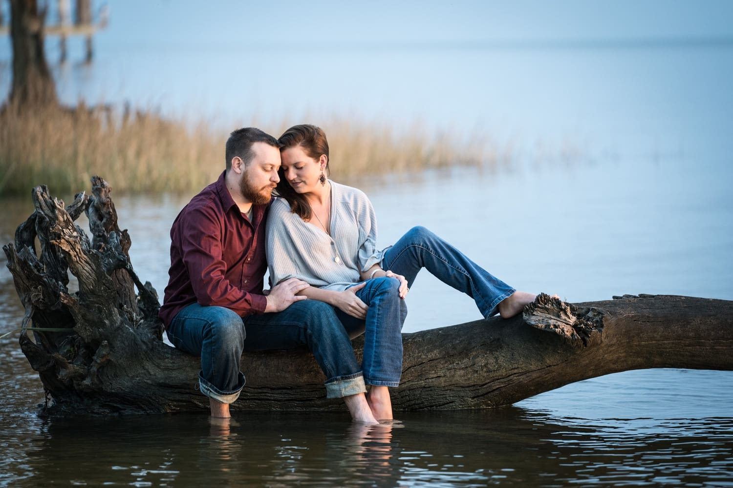 Couple sitting on log in water at Fontainebleau State Park in Mandeville