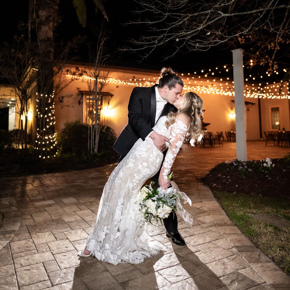 Groom dips bride in wedding day portrait at The Greystone venue in Mandeville