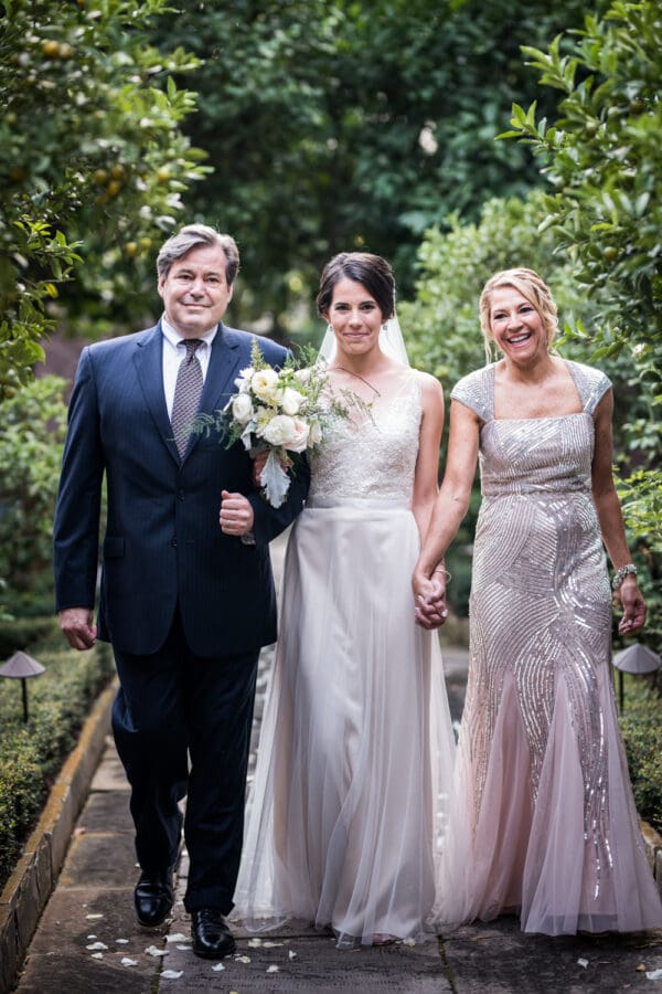 Bride and parents walk down aisle at Hermann-Grima House