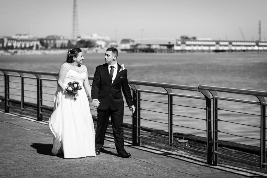 Bride and groom walking by the Mississippi River in New Orleans