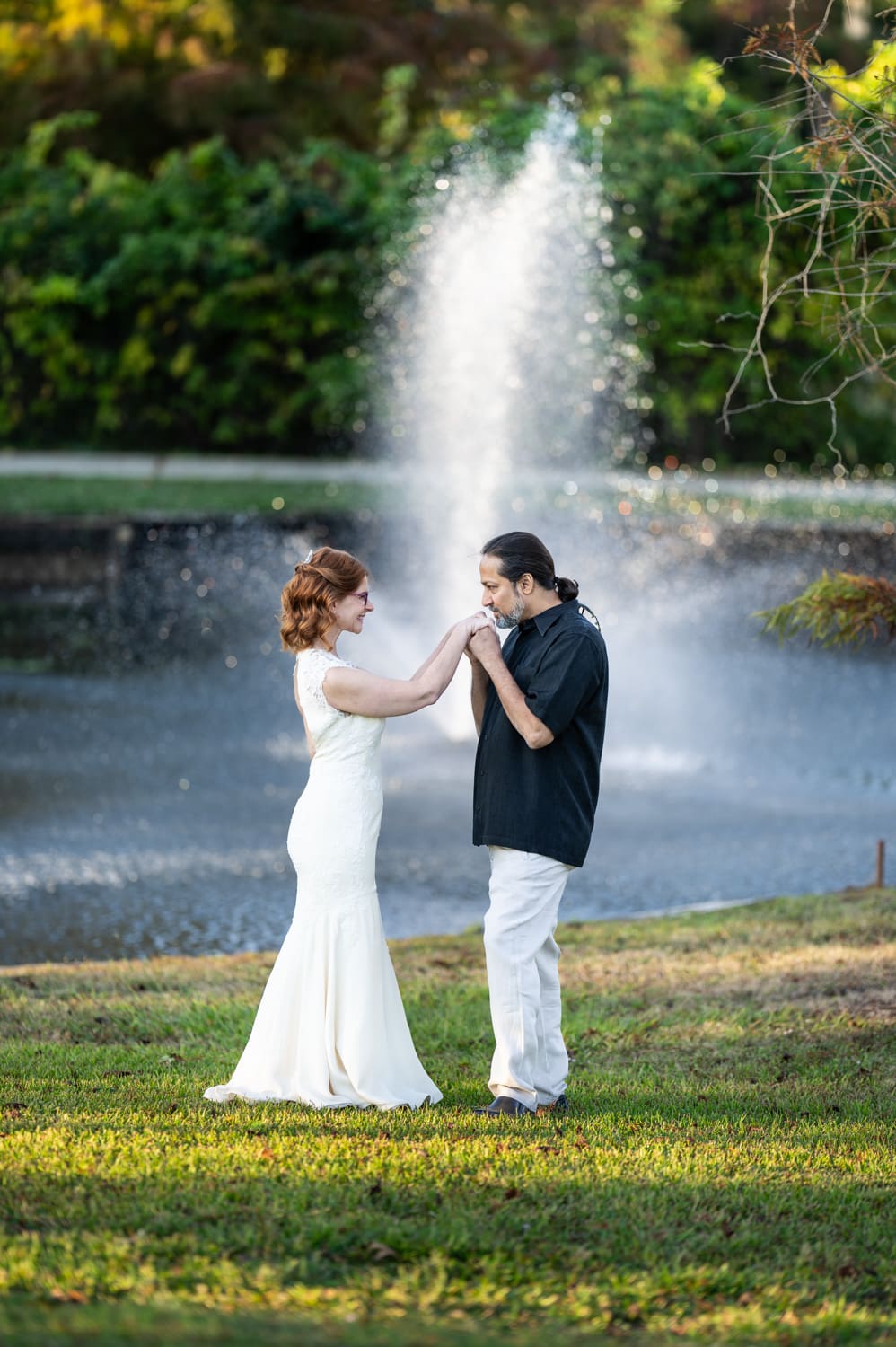 Bride and groom in front of pond and fountain