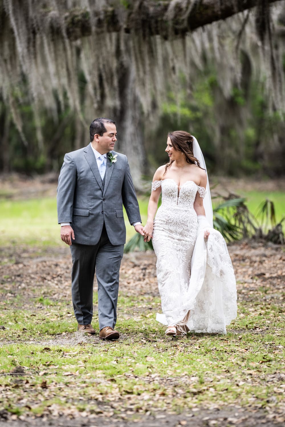 Bride and groom walking in Fontainebleau State Park with trees and moss in background