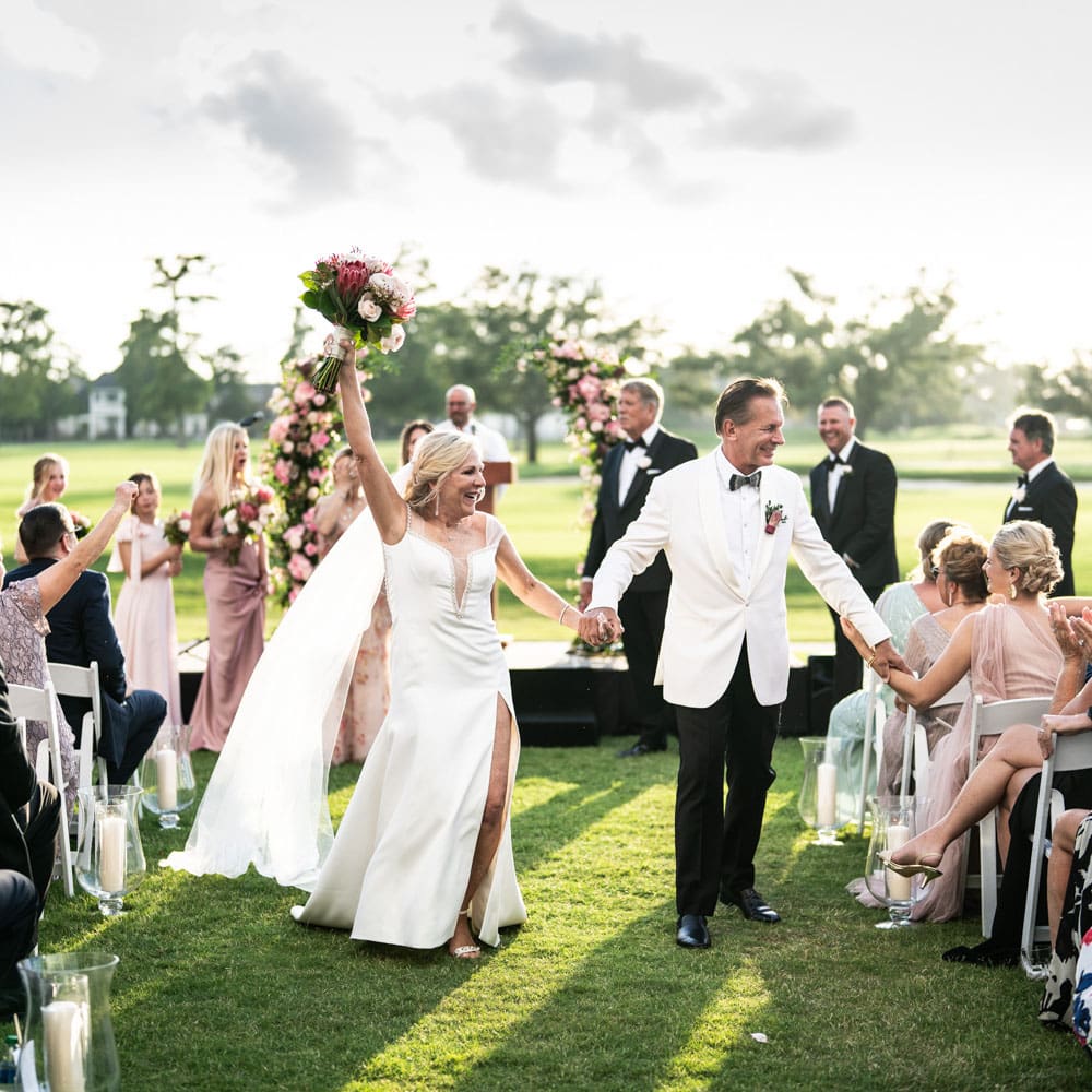 Bride and groom celebrate at the end of Metairie Country Club wedding ceremony