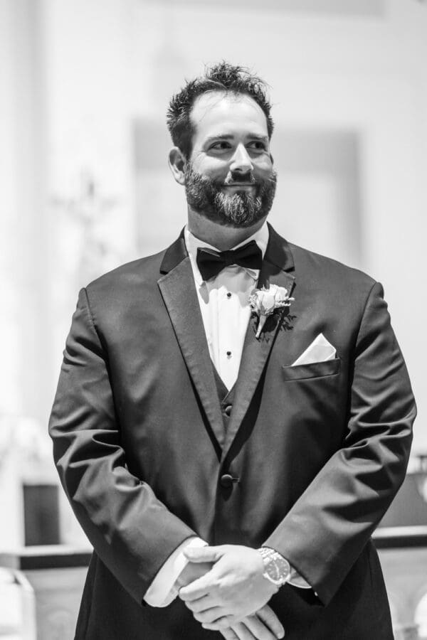 Groom smiles as bride comes up the aisle
