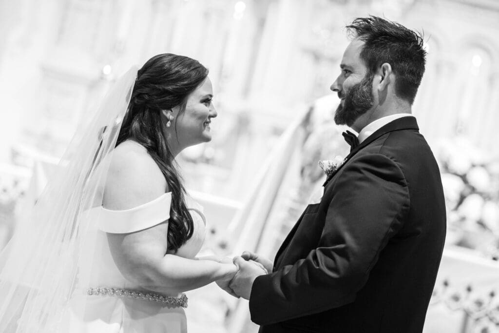 Bride and groom hold hands during wedding vows