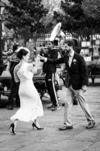 Couple dancing in front of brass band after eloping in New Orleans