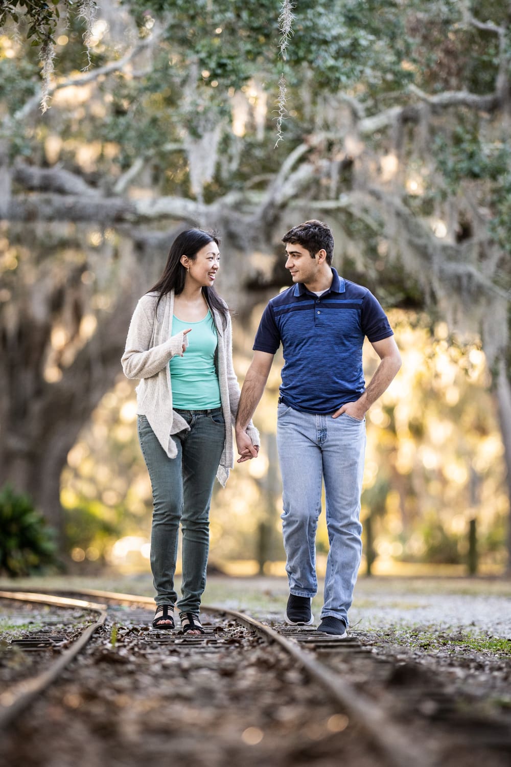 Couple walking along railroad tracks in New Orleans City Park