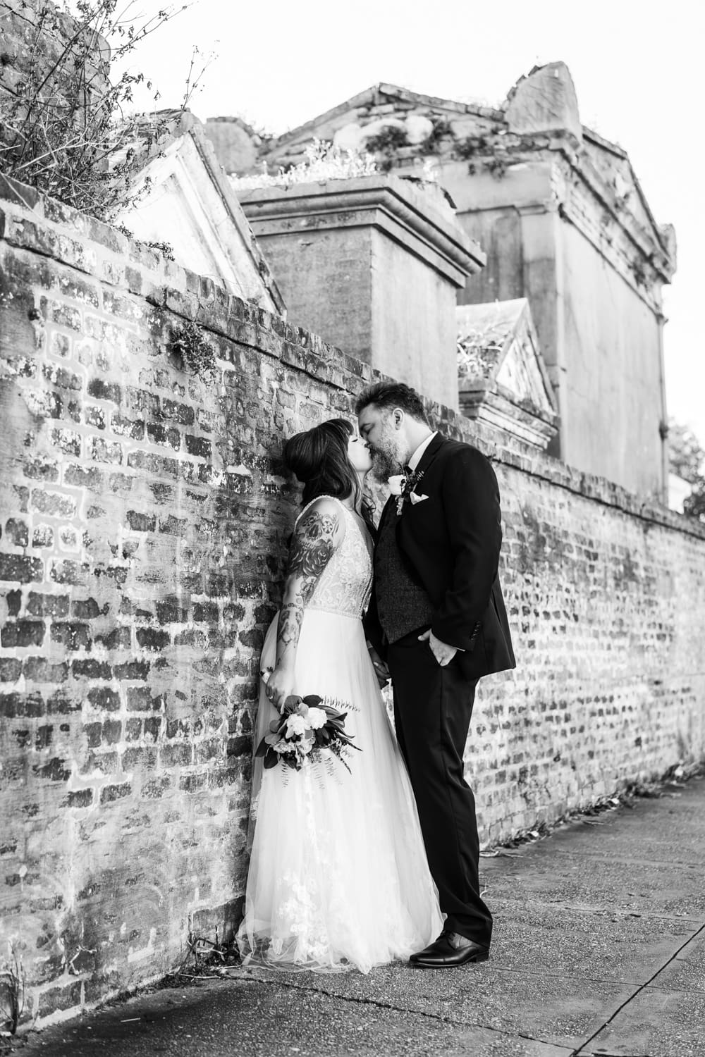 Couple kissing near cemetery wall in New Orleans