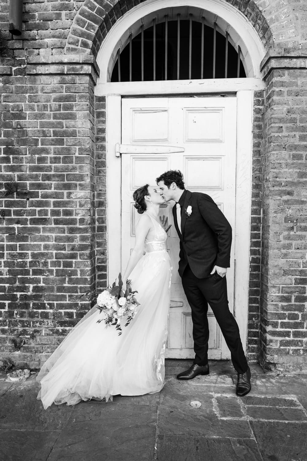 Bride and groom kissing in French Quarter doorway