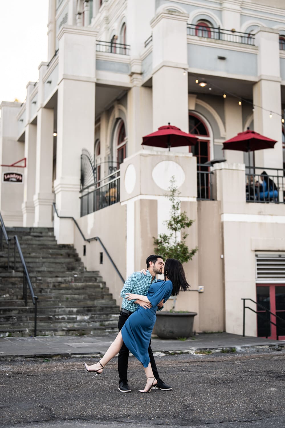 Couple kisses in front of Jax Brewery building in New Orleans