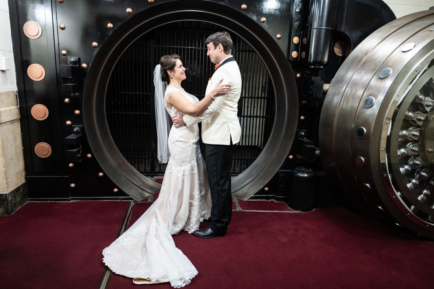 Bride and groom standing in front of vault door at Federal Ballroom in New Orleans