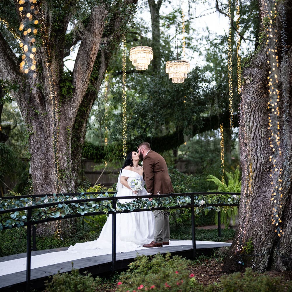 Bride and groom kiss on bridge at The Oaks wedding venue in Pontchatoula Louisiana