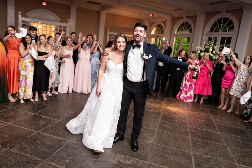 Guests sing and cheer on bride and groom at Pavilion of the Two Sisters wedding reception