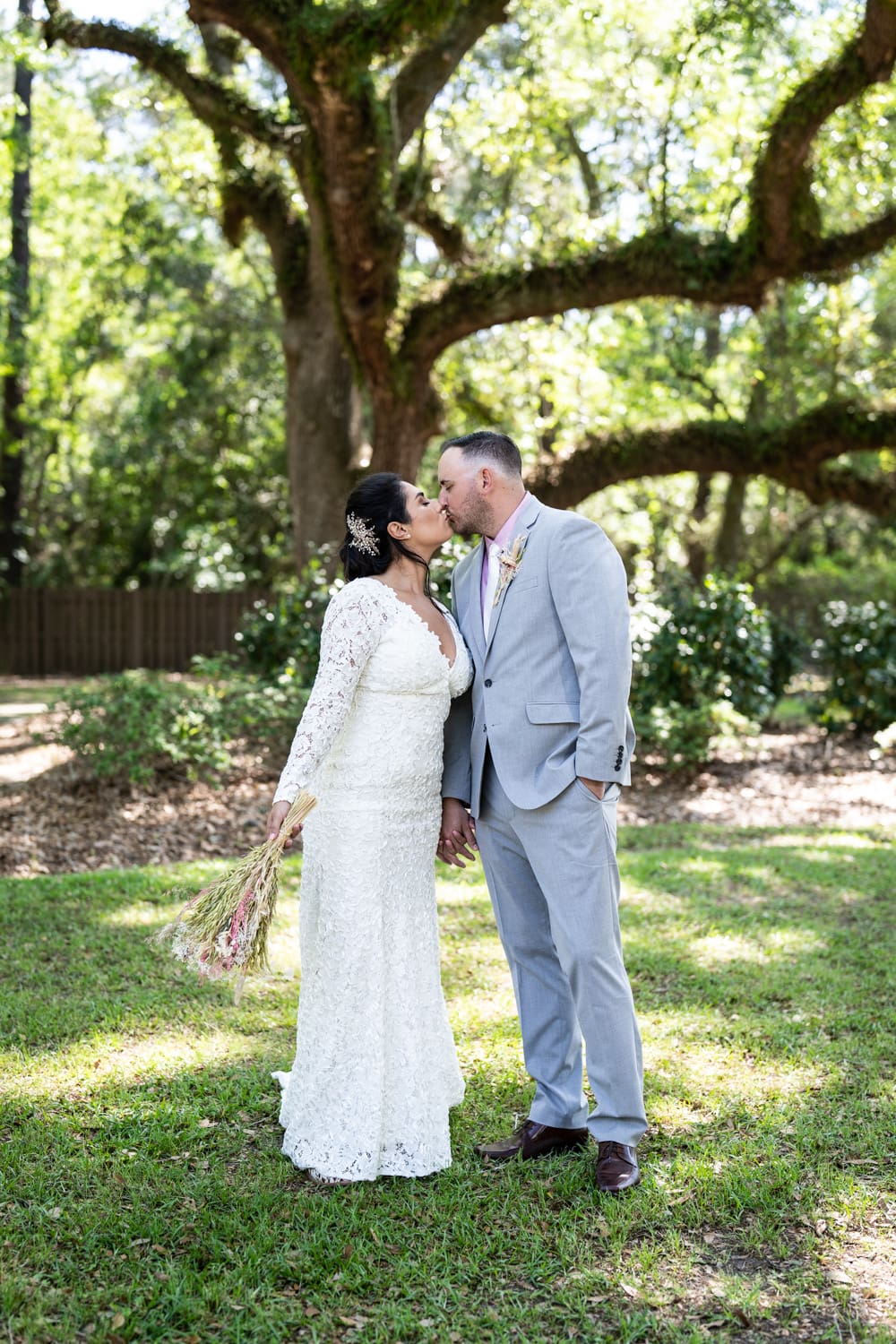 Couple kisses in front of oak tree