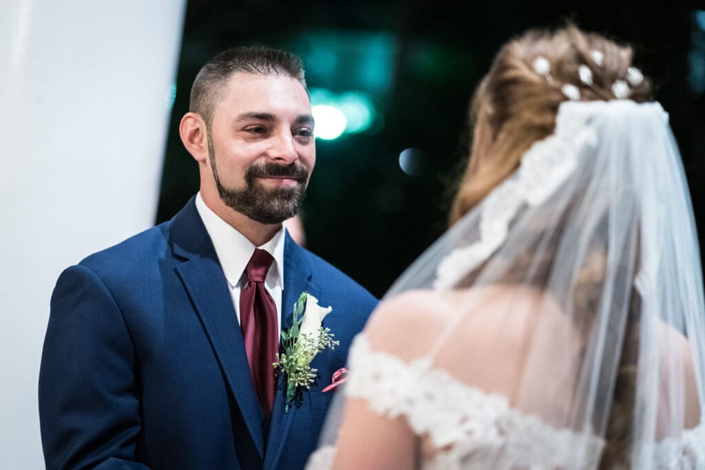 Groom smiles at bride