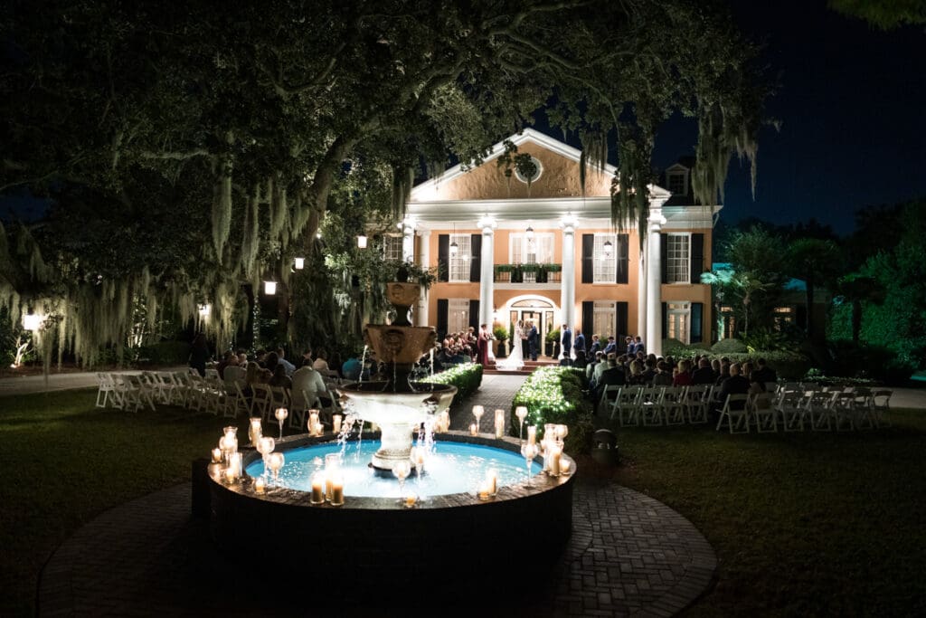 Night wedding ceremony at Southern Oaks with fountain decorated with candles in foreground