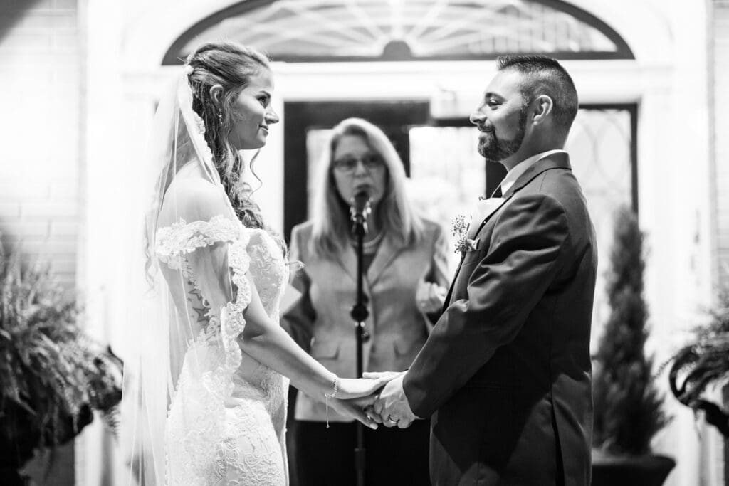 Bride and groom hold hands during wedding ceremony