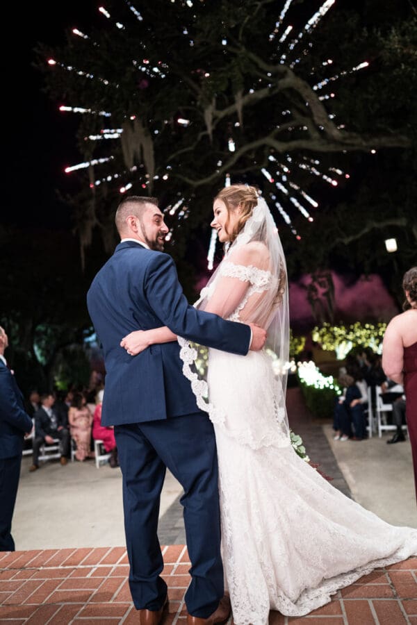 Bride and groom smile at each other during fireworks