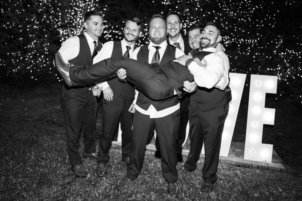 Groomsmen pick up the groom
