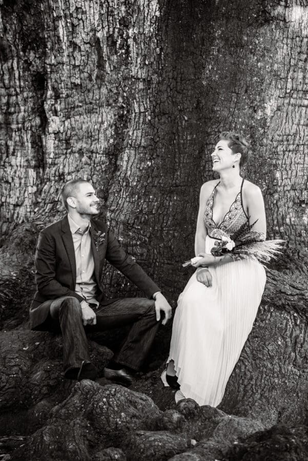 Couple sitting on roots of Tree of Life in Audubon Park