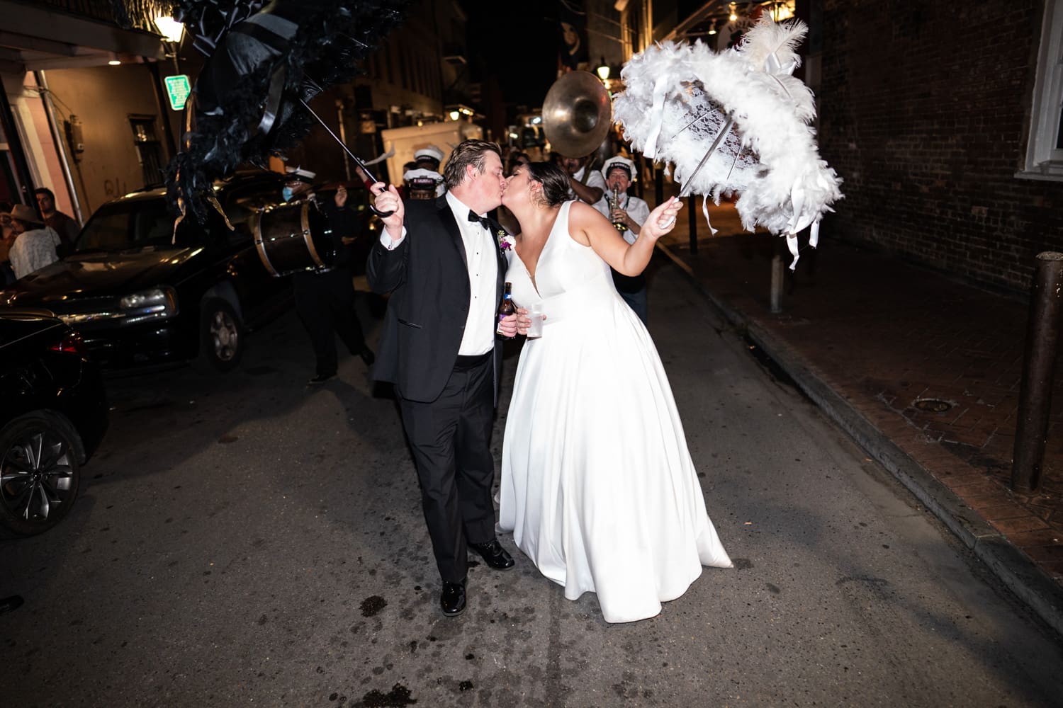 Bride and groom kissing during wedding second line parade