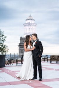 Bride and groom kiss on top of Capital on Baronne building