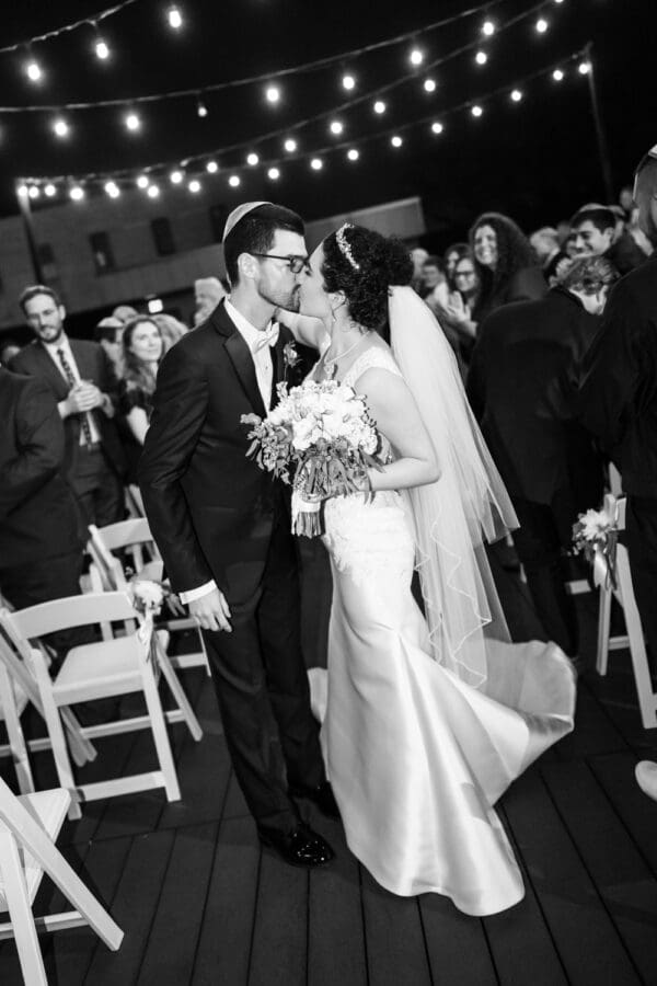 Bride and groom kiss in middle of aisle