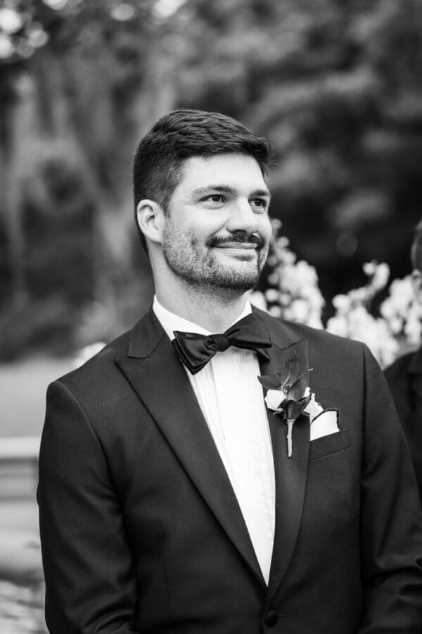 Groom smiles as he sees bride coming down the aisle