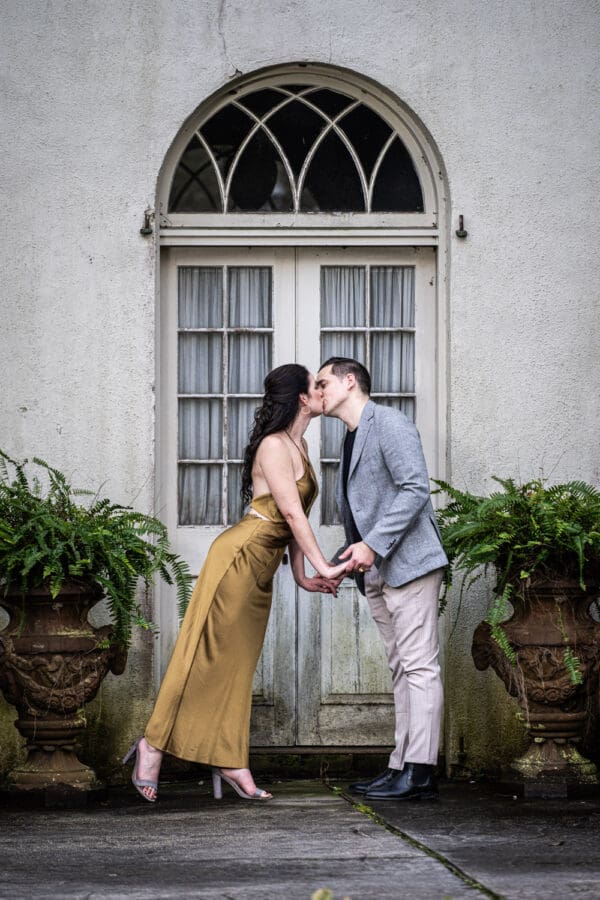 Couple kissing in front of doorway at Houmas House engagement portrait