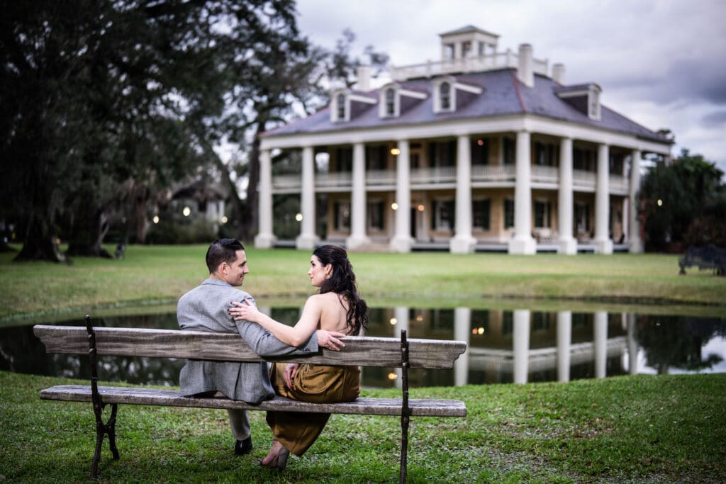 Couple sitting on bench during engagement portrait at Houmas House