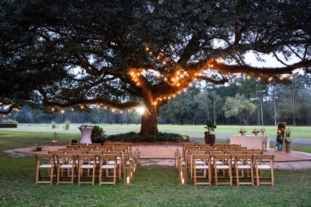 Evening ceremony setup at Garrett Field in Slidell in front of oak tree