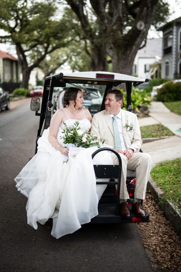 Couple riding on back of golf cart