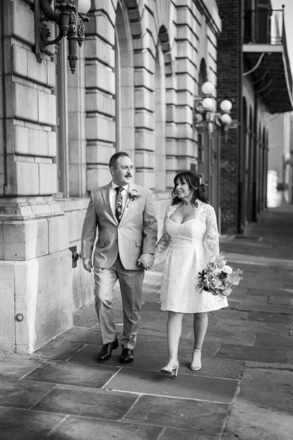 Bride and groom walk down sidewalk in New Orleans